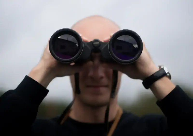 Man mit Fernglas als Spähtrupp zur Drohnenabwehr
